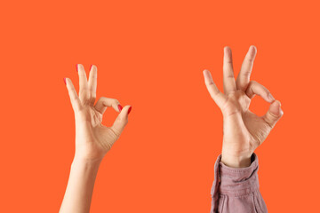 Obraz premium People showing OK on orange background