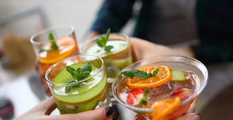 Close-up view of glasses with colourful cocktails and slices of fruits. Yummy drinks on fun party....
