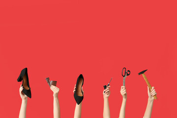 Female hands with shoes, hammer and craft tools on red background. Shoe repair concept