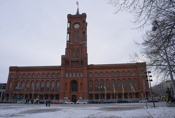 Berlin, Germany - Jan 21, 2024: Red Town Hall and Neptune Fountain in Berlin. Cloudy winter day. Selective focus
