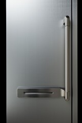 A modern stainless steel refrigerator with a sleek door handle. Suitable for kitchen and home interior designs