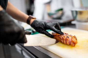 chef cuts fried meat to slices at the restaurant kitchen