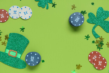 Frame made from poker chips and decorations for St. Patrick's Day celebration on green background