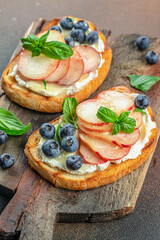 Sweet toast with ricotta cheese, honey and peach on a wooden board, Food recipe background. Close up