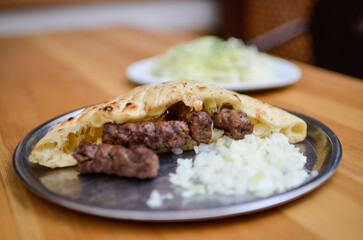 Ćevapi is a traditional bosnian meat dish with cutted onions.