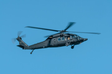 Military helicopter flying against the blue sky. Blackhawk helicopter