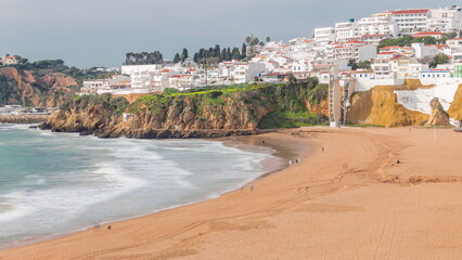 Fototapeta na wymiar Wide sandy beach and Atlantic ocean in city of Albufeira timelapse. Algarve, Portugal