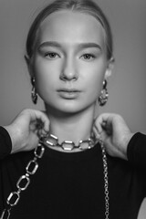 Close up glamour black and white portrait of blondie beautiful young girl in necklace and earings, fashion jewellery