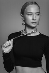 Close up glamour black and white portrait of blondie beautiful young girl in necklace and earings, fashion jewellery