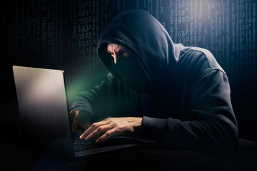 Pirate informatique masqué en train de pirater un ordinateur portable et qui demande une rançon devant un écran vert - obrazy, fototapety, plakaty