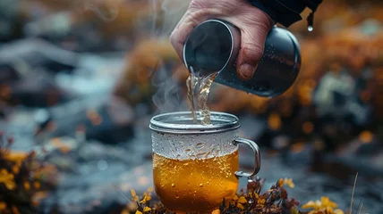 Fotobehang The process of pouring hot tea from a thermos. © SashaMagic