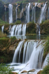 Fototapeta na wymiar The Nine Dragons Waterfall or Jiulong waterfall is located on Juilong river in Louping country. One of China 's top five beautiful waterfall group.