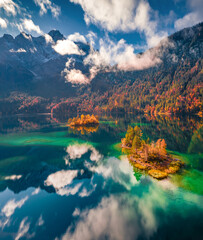 Captivating autumn view from flying drone of Eibsee lake with small islets. Majestic morning scene...