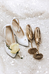 Bride's wedding ring on high-heeled shoes, women's perfume, wedding glasses. Wedding details. High quality photo