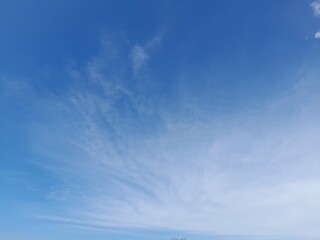 Beautiful white clouds on deep blue sky background. Large bright soft fluffy clouds are cover the...