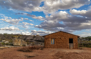 Visão geral da entrada do Lajedo Pai Mateus, com casa construída com barro, de pau à pique em...