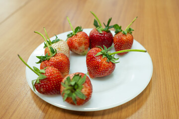 Strawberries on a white plate are fruits that are very rich in vitamins and nutrients.