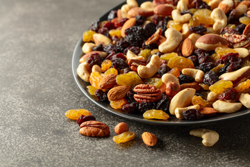 Mix of dried nuts and raisins on a rustic background.