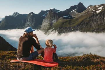 Family picnic father and daughter eating snacks in mountains travel vacations camping outdoor dad with child hiking together active lifestyle adventure trip parent and kid enjoying views in Norway - obrazy, fototapety, plakaty