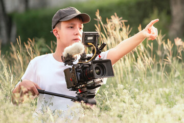 Teenage boy operating a digital camera to tell the story in the new generation movie. content...
