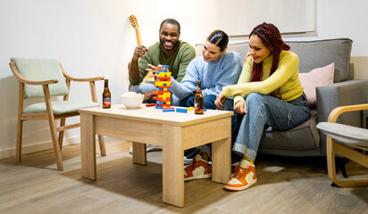 A group of 3 multiethnic young people have fun in a cozy apartment. Young people play a board game...