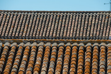 Traditional old Spanish ceramic roof tiles on a building, characteristic elements of Mediterranean architecture
