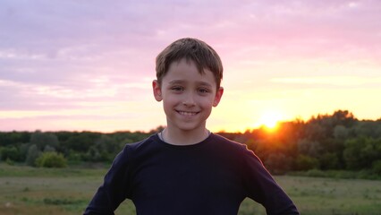 Portrait of a happy child. The boy is looking and laughing. Beautiful bright purple sky, sunset, child in the park. alone with nature