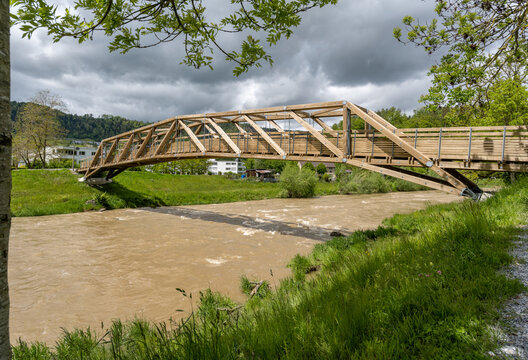 Holzbrücke über einen Fluss mit Regenwolke