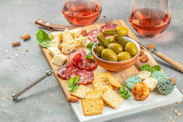 Antipasto catering platter with salami, crackers, cheese, olives and rose wine. place for text, top view