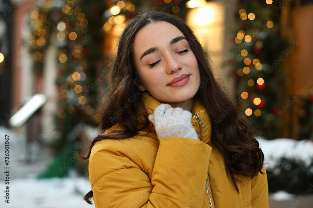 Wall mural Portrait of beautiful woman on city street in winter