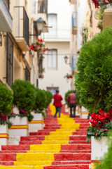 Fototapeta na wymiar Stairs in the old quarter of Calpe painted with red and yellow colors.