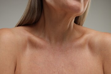 Naklejka premium Mature woman with healthy skin on grey background, closeup