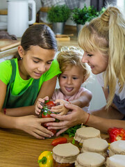 Family canning vegetables in jars in the kitchen. Selective focus.