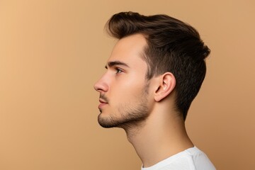 Fototapeta premium Profile photo of confident young handsome man with stubble on beige background