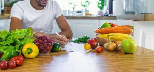 A nutritionist writes a nutrition plan. Selective focus.