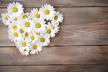 Fototapeta premium top view of daisies in shape of a heart on wooden background