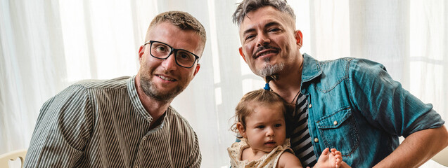 Horizontal banner or header with portrait of happy LGBTQ family at home - Gay couple and their...