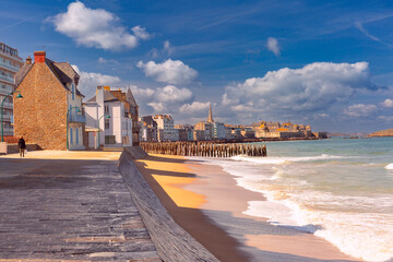 Sunny promenade and beach of beautiful walled port city of Saint-Malo at high tide, Brittany, France