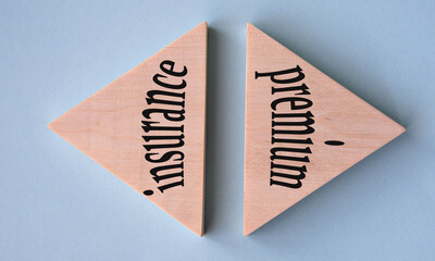 INSURANCE PREMIUM - words on wooden triangles on grey-blue background
