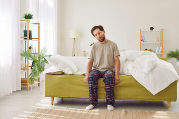 Man is trying to wake up from sleep on a very early Monday morning. Sleepy, tired man in a T shirt...