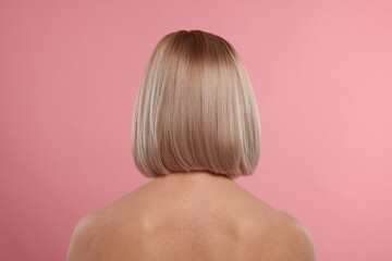 Woman with healthy skin on pink background, back view