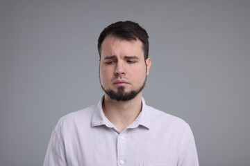 Portrait of sad man on grey background