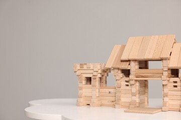 Wooden entry gate and box on white table against light grey background, space for text. Children's toy
