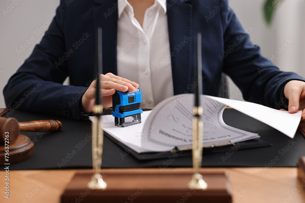 Poster Notary stamping document at table in office, closeup