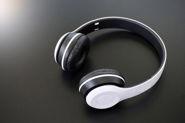 White wireless Bluetooth headphones on black background. The highlight of wireless Bluetooth...
