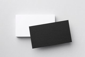 Blank black and white business cards on light background, top view. Mockup for design