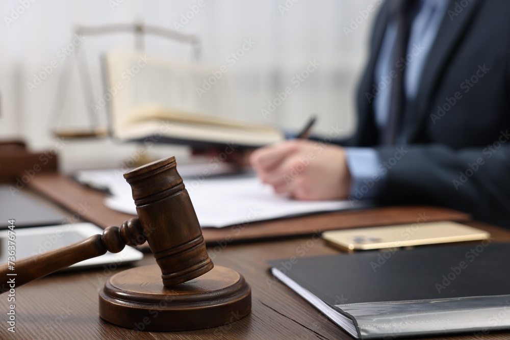 Sticker Lawyer working with documents at wooden table, focus on gavel