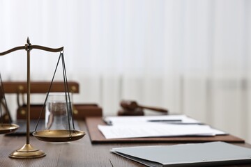 Lawyer's workplace. Scales of justice, folder and documents on wooden table indoors, space for text