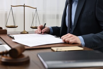 Lawyer working with documents at table indoors, closeup