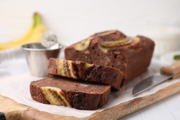 Delicious banana bread on white tiled table, closeup
